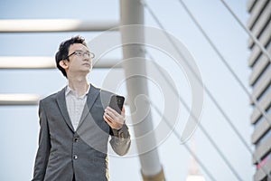 Business Man hands holding mobile phone outdoor surfing internet online technology lifestyle in city street. Entrepreneur young