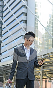 Business Man hands holding mobile phone outdoor surfing internet online technology lifestyle in city street. Entrepreneur young