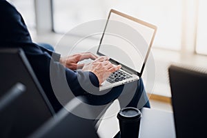 Business man hands on a laptop using wi-fi internet in airport. Close-up of a man`s hands typing message on a keyboard