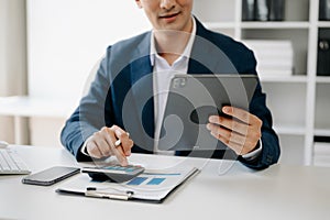Business man hands is typing on a laptop and holding smartphone at office photo