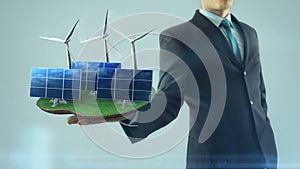 Business man has on hand green energy concept build animation solar panel and windmill