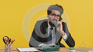 Business man having annoyed boring talking on wired vintage telephone, fooling making silly faces