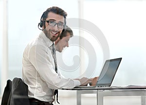 Business man in headphones sitting at his Desk