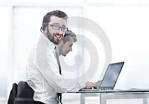 Business man in headphones sitting at his Desk