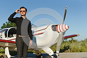 Business man with his airplanes. He is walking in the airport with the smart phone and making a call