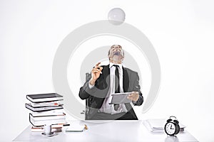 Business man hitting the ball with head holding an ipad