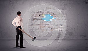 Business man hitting brick wall with hammer