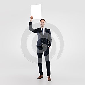 Business man holding blank white advertising billboard at studio