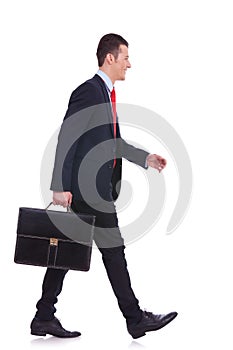 Business man holding brief case and walking