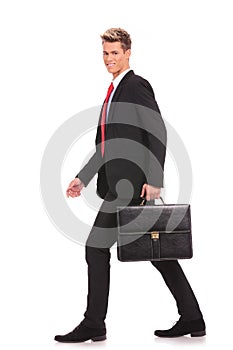 Business man holding brief case and walking