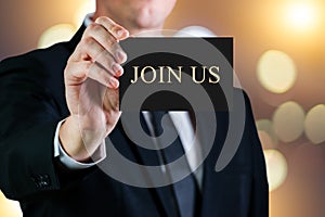 Business man holding a card on a luxury background. Join us message text. Hire or career concept