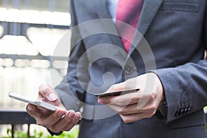 Business man holding a credit card and using smartphone to make mobile payment