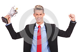 Business man holding a cup trophy over white