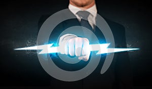 Business man holding glowing lightning bolt in his hands