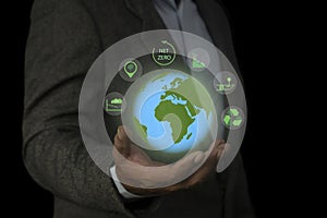 Business man holding green earth and Net Zero icon for net zero emissions target. Environment Social and Governance, Carbon