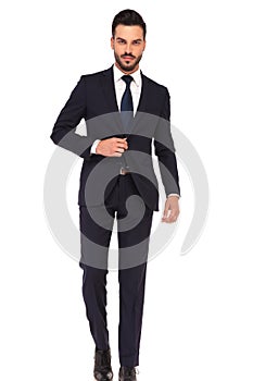 Business man holding hand on suit`s button is stepping forward