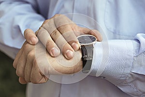 Business man holding hands watching on his watch