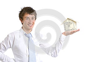 Business man holding a house made of money
