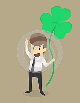 A business man holding a leaf clover who are lucky