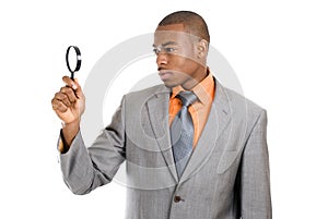 Business man holding magnifying glass