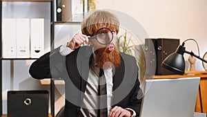 Business man holding magnifying glass near face, looking with big zoomed eye, searching, analysing