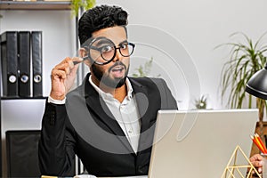 Business man holding magnifying glass near face, looking with big zoomed eye, searching, analyzing