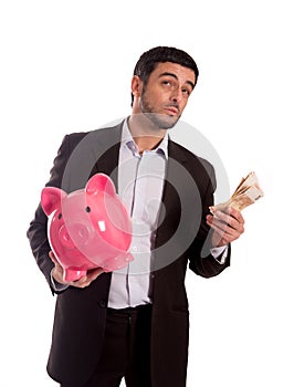 Business man holding piggy bank with money