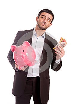 Business man holding piggy bank with money