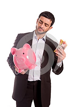 Business man holding piggy bank with money