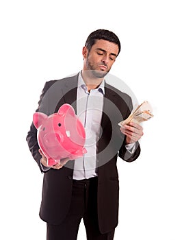 Business man holding piggy bank with money