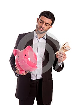 Business man holding piggy bank with money