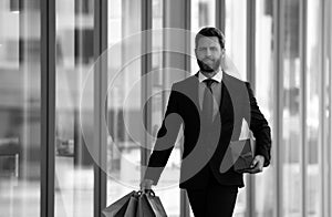 Business man holding shopping bags and walking in shopping store. Shopping and paying. Shopaholic shopping concept.