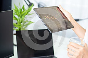 Business man holding smart device with stock graph