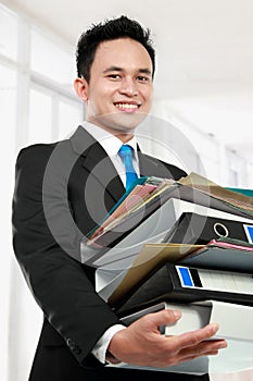 Business man holding stack of files and folders