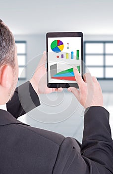 Business man holding tablet with financial charts