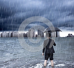 Business man holding an umbrella and standing with cloudburst photo