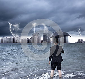 Business man holding an umbrella with thundershower photo