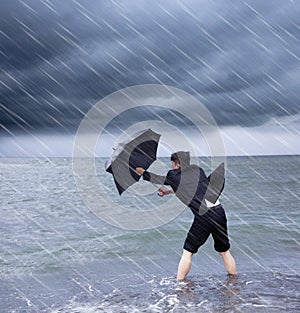 Business man holding a umbrella to resist rainstorm