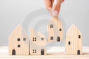 Business man holding wooden house model on table background. Home, Crisis, Economic recession, Homeless, Real Estate, Buy or Rent
