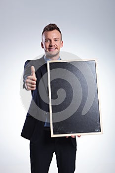 Business man holds a blackboard and shows ok