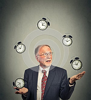 Business man juggling multiple alarm clocks