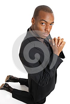 Business man kneeling doing a prayer gesture