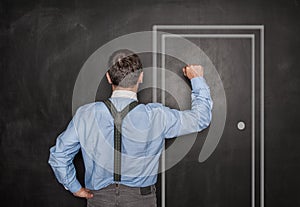 Business man knock by fist on blackboard. Opportunity concept