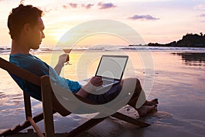 Business man with laptop on the beach