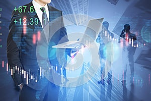 Business man with laptop and businesspeople working together on abstract city background with forex chart. Teamwork, trade,