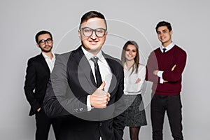 Business man leading a successful corporate group with thumbs up isolated on white