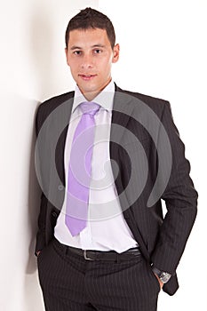 Business man leaning against wall