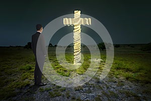 Business man looking cross shape with christmas lights decoration