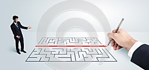 Business man looking at hand drawing solution for maze