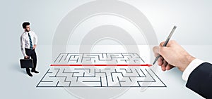 Business man looking at hand drawing solution for maze